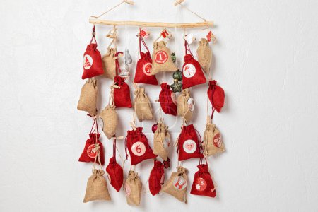 Handgemachter Adventskalender. Geschenktüten hängen am Seil. Umweltfreundliche Weihnachtsgeschenke diy Konzept