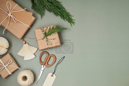 Téléchargez les photos : Fond de Noël avec boîtes cadeaux et papier d'emballage kraft. Fête de Noël, préparation pour les vacances d'hiver. Modèle festif, vue sur le dessus, flatlay - en image libre de droit