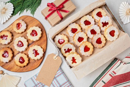 Téléchargez les photos : Biscuits traditionnels Linzer ou sandwich remplis de confiture de framboise emballés dans des boîtes-cadeaux. Emballages cadeaux faits main de Noël, petite entreprise, idée de cuisson à la maison - en image libre de droit