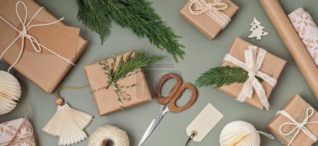 Téléchargez les photos : Fond de Noël avec boîtes cadeaux et papier d'emballage kraft. Fête de Noël, préparation pour les vacances d'hiver. Modèle festif, vue sur le dessus, flatlay - en image libre de droit