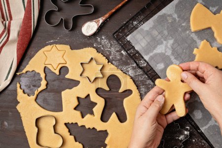 Photo for Christmas cookies baking process. Cutting buiscuits with cookies cutter. Homemade treats, diy festive dessert idea - Royalty Free Image