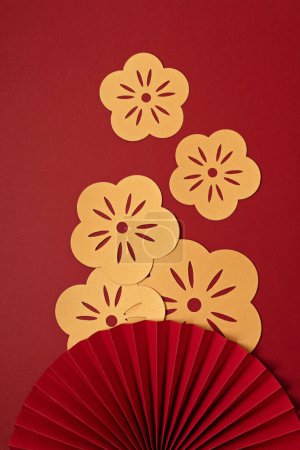 Téléchargez les photos : Chinese new year festival or wedding decoration over red background. Traditional lunar new year paper fans. Flat lay, top view, banner - en image libre de droit