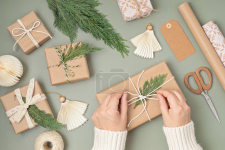 Téléchargez les photos : Fond de Noël avec des boîtes-cadeaux et des rouleaux de papier d'emballage kraft coloré. Fête de Noël, préparation pour les vacances d'hiver. Modèle festif, vue sur le dessus, flatlay - en image libre de droit