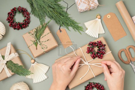 Téléchargez les photos : Fond de Noël avec des boîtes-cadeaux et des rouleaux de papier d'emballage kraft coloré. Fête de Noël, préparation pour les vacances d'hiver. Modèle festif, vue sur le dessus, flatlay - en image libre de droit