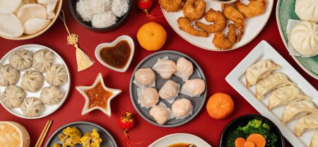 Téléchargez les photos : Table de festival du Nouvel An chinois sur fond rouge. Nourriture traditionnelle du Nouvel An lunaire. Couché plat, vue du dessus - en image libre de droit