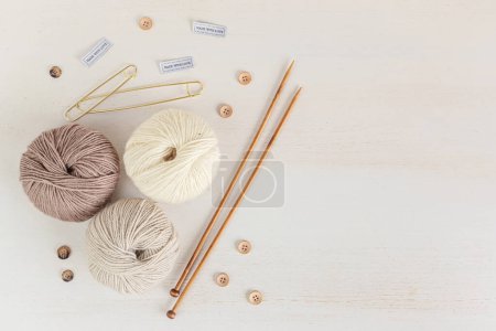 Foto de Craft knitting hobby background with yarn in natural colors. Recomforting hobby to reduce stress for cold fall and winter weather. Mock up, copy space, top view - Imagen libre de derechos