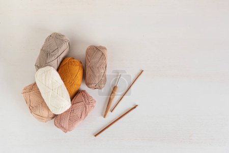 Téléchargez les photos : Craft knitting hobby background with yarn in natural colors. Recomforting hobby to reduce stress for cold fall and winter weather. Mock up, copy space, top view - en image libre de droit