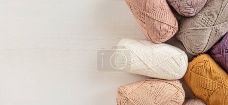 Foto de Craft knitting hobby background with yarn in natural colors. Recomforting hobby to reduce stress for cold fall and winter weather. Mock up, copy space, top view - Imagen libre de derechos