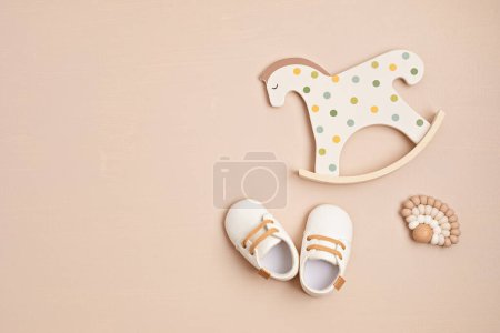 Téléchargez les photos : Gender neutral baby shoes, rocking horse and teether. Organic newborn fashion, branding, small business idea - en image libre de droit