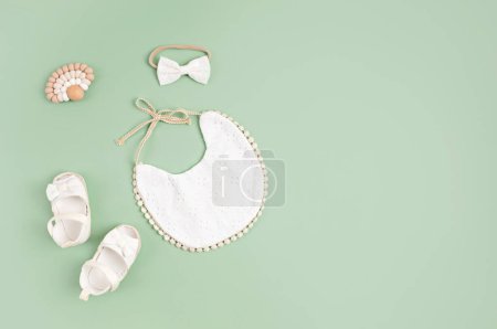 Photo for Baby shoes, bib and teether. Organic newborn accessories, branding, small business idea. Baby shower invitation, greeting card. Flat lay, top view - Royalty Free Image