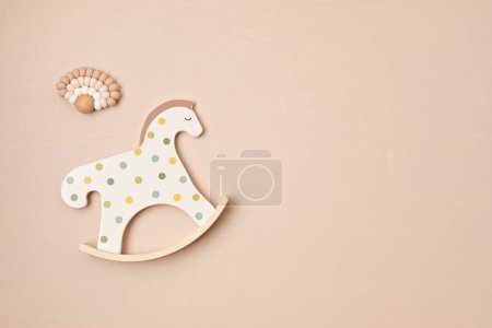 Téléchargez les photos : Jouet de cheval à bascule mignon et attache sur fond beige. cadeaux bio et respectueux de l'environnement pour nouveau-né - en image libre de droit