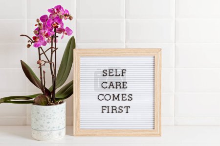 Téléchargez les photos : Bathroom styling and organization. Letter board with text Self care comes first. Organic lifestyle and skin care products. - en image libre de droit