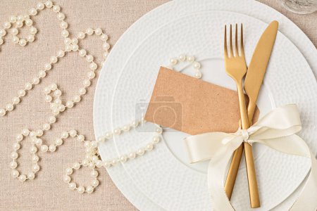 Téléchargez les photos : Festive wedding, birthday table setting with golden cutlery and porcelain plate. Blank place card mockup. Party menu template. Flat lay, top view - en image libre de droit