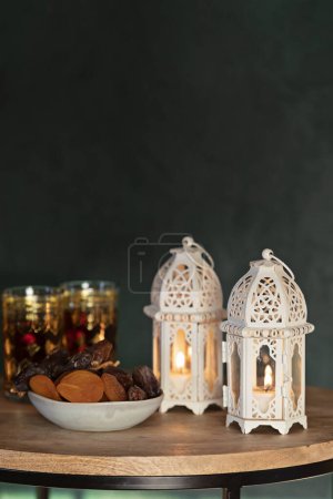 Foto de Ramadán Kareem e iftar comida musulmana, concepto de vacaciones. Bandejas con frutos secos y frutos secos y charranes con velas. Idea de celebración - Imagen libre de derechos