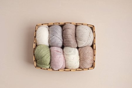 Craft knitting hobby background with yarn in natural colors. Recomforting hobby to reduce stress for cold fall and winter weather. Mock up, copy space, top view