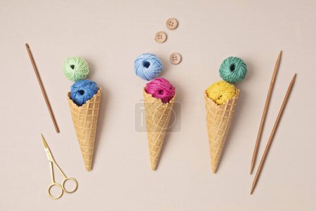 Téléchargez les photos : Colorful balls of organic cotton yarn waffle cones for ice cream . Recomforting hobby to reduce stress - en image libre de droit