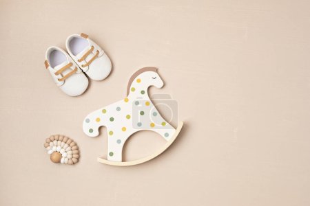 Foto de Gender neutral baby shoes, rocking horse and teether. Organic newborn fashion, branding, small business idea - Imagen libre de derechos