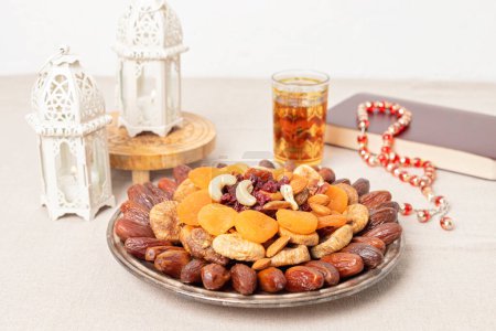 Foto de Ramadán Kareem e iftar comida musulmana, concepto de vacaciones. Bandejas con frutos secos y frutos secos y charranes con velas. Idea de celebración - Imagen libre de derechos