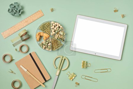 Photo for Mockup of pad or tablet computer and office supplies with white screen copy space for your text. Flat lay, top view photo mock up. - Royalty Free Image