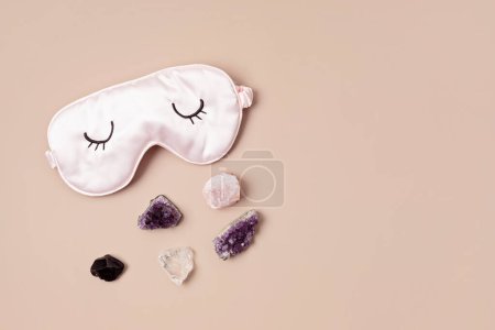Foto de Cristales de chakra curativos y máscara para dormir. Mejorar la calidad del sueño con piedras preciosas. Terapia alternativa para el concepto de bienestar físico, mental, emocional y espiritual - Imagen libre de derechos
