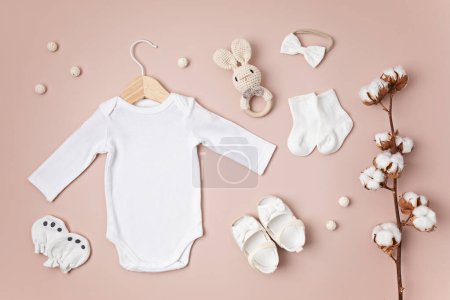 Photo for Mockup of white infant bodysuit made of organic cotton with eco friendly baby accessories. Onesie template for brand, logo, advertising. Flat lay, top view - Royalty Free Image
