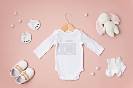 Téléchargez les photos : Maquette de body pour bébé blanc en coton biologique avec accessoires pour bébé respectueux de l'environnement. Modèle Onesie pour la marque, logo, publicité. Couché plat, vue du dessus - en image libre de droit
