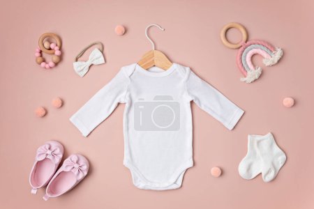 Téléchargez les photos : Maquette de body pour bébé blanc en coton biologique avec accessoires pour bébé respectueux de l'environnement. Modèle Onesie pour la marque, logo, publicité. Couché plat, vue du dessus - en image libre de droit
