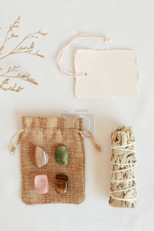 Photo for Crystals kit for confidence and self esteem. Moonstone, jade, roze quartz, tiger eye gemstones for courage and self worth gift idea. Flat lay, top view with tag mockup - Royalty Free Image