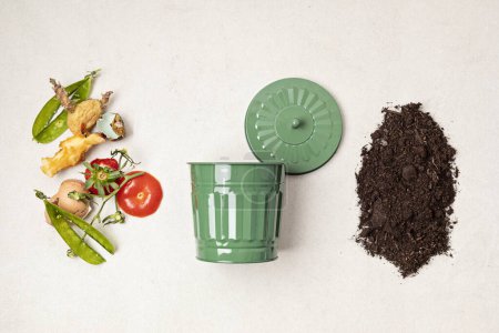 Téléchargez les photos : Poubelle à compost vert et restes de cuisine. Recyclage des escarpements, concept de vie durable et zéro déchet. Fruits et déchets végétaux se transformant en sol fertilisant organique. Vue du dessus, flatlay - en image libre de droit