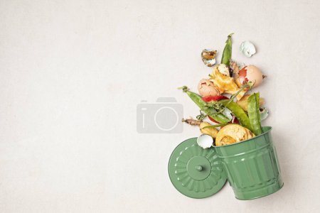 Téléchargez les photos : Poubelle à compost vert et restes de cuisine. Recyclage des escarpements, concept de vie durable et zéro déchet. Fruits et déchets végétaux se transformant en sol fertilisant organique. Vue du dessus, flatlay - en image libre de droit