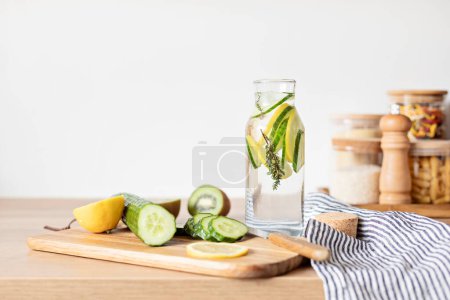 Téléchargez les photos : Eau infusée de concombre, citron et thym dans une bouteille en verre sur une table en bois. Régime alimentaire, désintoxication, saine alimentation, concept de perte de poids - en image libre de droit