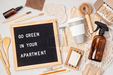 Photo for Zero waste home accessories and letter board with the text go green in your apartment. Sustainable, eco friendly lifestyle idea. Flat lay, top, view - Royalty Free Image