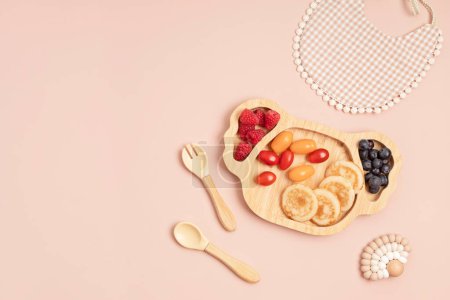 Photo for Top view of healthy breakfast for picky toddler with pancakes, tomatoes and berries. First safe plate and tableware for baby and toddler. Flat lay - Royalty Free Image