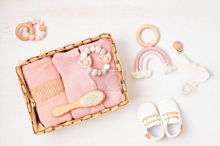 Photo for Gift basket with gender neutral baby garment and accessories. Care box of organic newborn booties, fashion, branding, small business idea. Flat lay, top view - Royalty Free Image