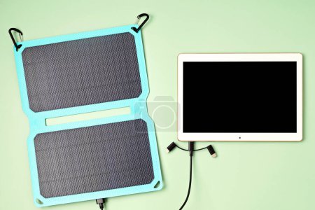 Photo for Solar battery charger for mobile devices. Concept of sustainable lifestyle and green renewable energy - Royalty Free Image