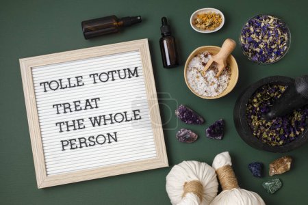 Photo for Letter board with text Tolle totum meaning treat the whole person in latin. Naturopatical principle. Botanical blends, herbs, essencial oils for naturopathy. Natural remedy, herbal medicine concept - Royalty Free Image