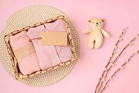 Photo for Gift basket with gender neutral baby garment and accessories. Care box of organic newborn clothes, fashion, branding, small business idea. Flat lay, top view - Royalty Free Image