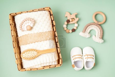 Photo for Gift basket with gender neutral baby garment and accessories. Care box of organic newborn clothes, fashion, branding, small business idea. Flat lay, top view - Royalty Free Image