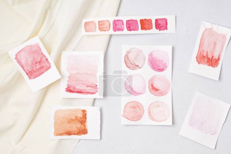 Photo for Artist painting watercolor palettes in pink and warm pastel tones with brushes. Craft artistic background. Recomforting, destressing hobby, art therapy - Royalty Free Image