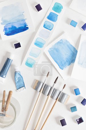 Photo for Artist painting watercolor palettes in blue pastel with brushes. Craft artistic background. Recomforting, destressing hobby, art - Royalty Free Image