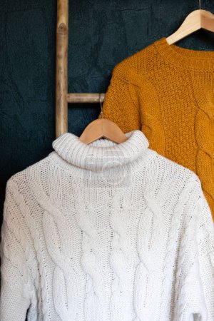 Photo for Warm autumn sweaters on hangers. Comfort knitwear for cold days of fall, winter. Fashion, thifting, sustainable second hand shopping idea - Royalty Free Image
