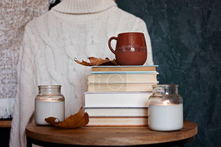 Photo for Composition with a stack of books, hot beverage in the mug and warm blanket. Cozy reading scene for cold weather with cup of coffee - Royalty Free Image