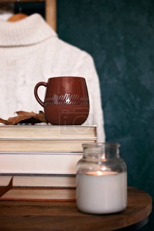 Photo for Composition with a stack of books, hot beverage in the mug and warm blanket. Cozy reading scene for cold weather with cup of coffee - Royalty Free Image