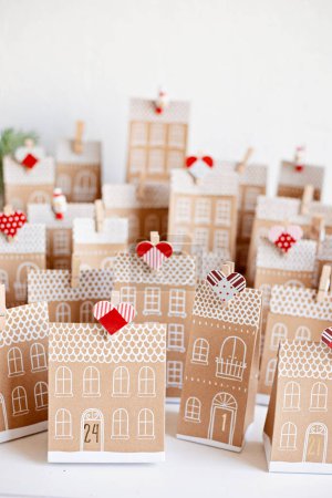 Foto de Calendario de Adviento hecho a mano. Casas en forma de cajas de regalo de cartón. Eco amigable Navidad regalos concepto bricolaje - Imagen libre de derechos