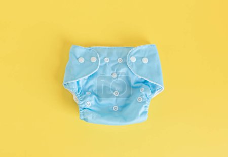Téléchargez les photos : Pose plate avec des couches pour bébés en tissu réutilisable. Couches écologiques sur fond pastel. Style de vie durable, idée zéro déchet - en image libre de droit