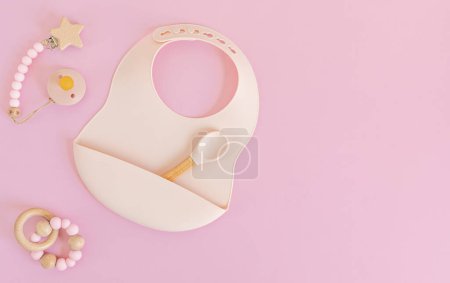 Photo for Flat lay with plate and bib for baby feeding, first baby solid food idea. Top view in pastel colors - Royalty Free Image