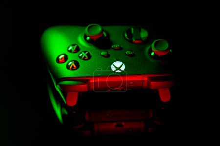 Foto de January 9, 2023, Odessa, Ukraine. A black Xbox Wireless Controller highlighted in green and red. Compatible Xbox Series X|S, Xbox One on a dark background. - Imagen libre de derechos