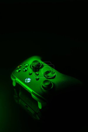 Photo for January 9, 2023, Odessa, Ukraine. A black Xbox Wireless Controller highlighted in green. Compatible Xbox Series X|S, Xbox One on a dark background. - Royalty Free Image