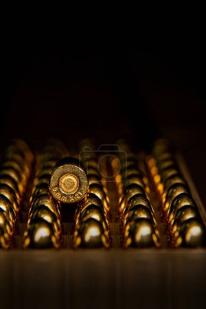Foto de Cartuchos de pistola 9 mm. Munición para pistolas y carabinas PCC sobre fondo oscuro. - Imagen libre de derechos