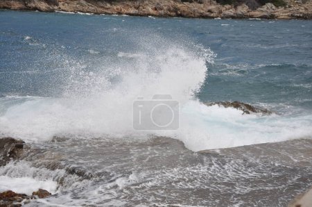 Foto de La ola del mar chocando contra la roca y hacer que el agua salpicando y burbuja de espuma de aire blanco. Rompiendo olas en la playa.Rompiendo olas marinas en la costa rocosa - Imagen libre de derechos
